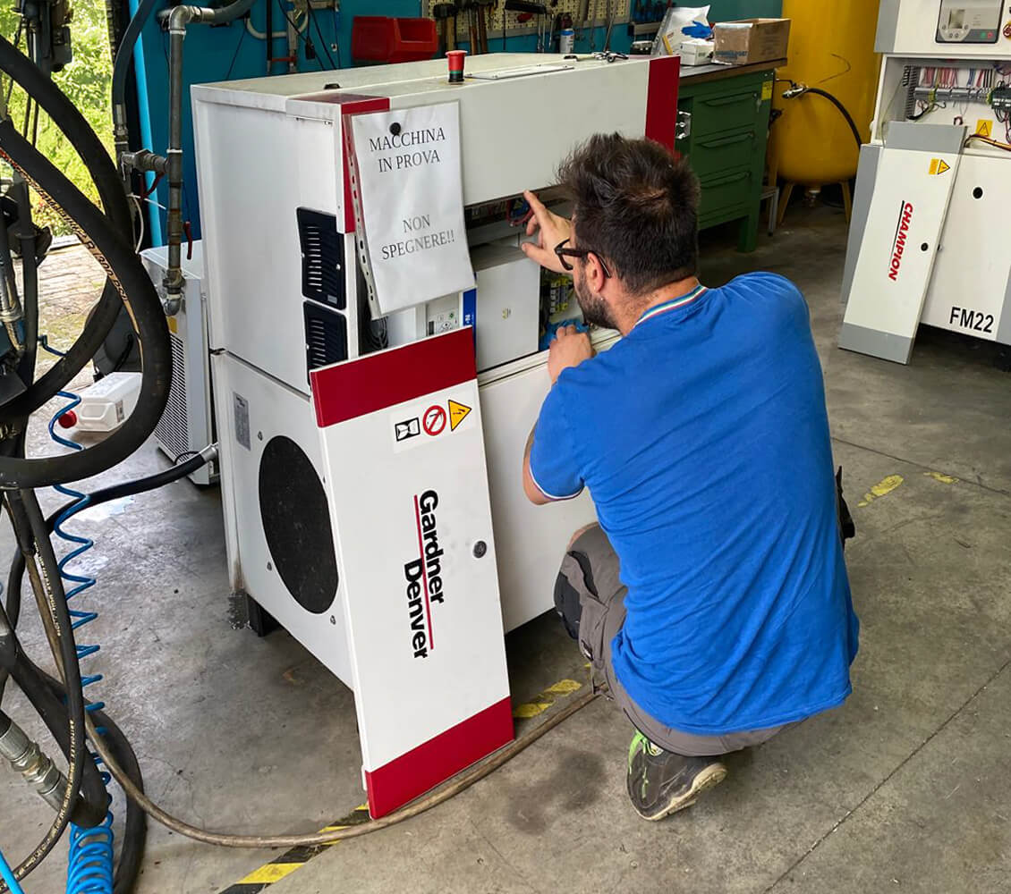 Tecnico specializzato durante un intervento di assistenza compressore industriale