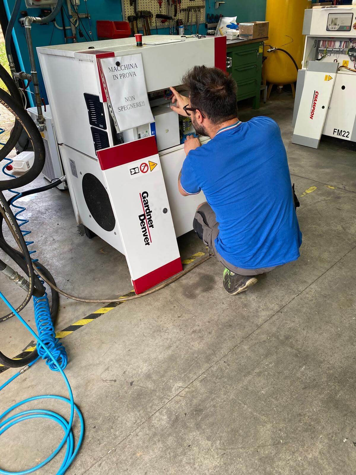 Tecnico specializzato durante un intervento di manutenzione impianti aria compressa in ambiente industriale